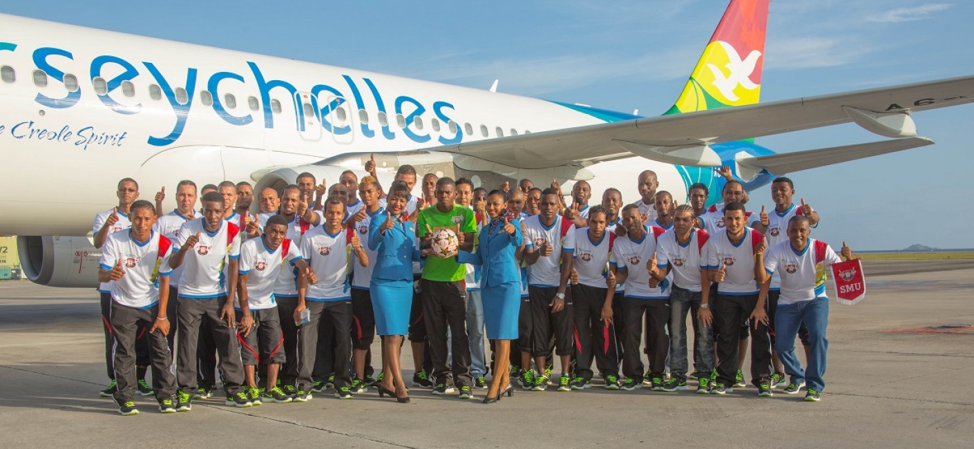 St Michel United players pose with Air Seychelles cabin crew before their early morning flight to South Africa