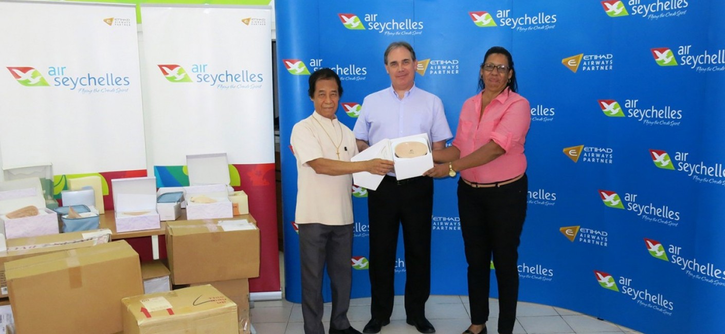 Bishop Chang Him, Chairman of the Cancer Concern Association, Roy Kinnear, Chief Executive Officer of Air Seychelles, and Elizabeth Julienne, mother of Dr Sophia Harryba, hold one of 177 prostheses flown to Seychelles by Air Seychelles and Etihad Airways