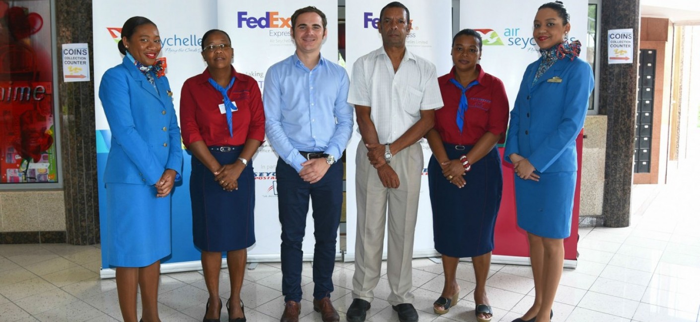 Ben Simkin, Head of Cargo at Air Seychelles, and Errol Dias, Chief Executive Officer of Seychelles Postal Services, standing outside the Grand Anse post office on Praslin, where FedEx services are now available