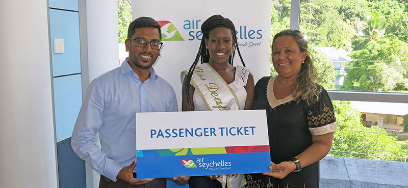Manoj Papa, Chief Executive Officer of Air Seychelles, presents Melita Gilbert and Anita Gardner with tickets to South Africa before their departure.