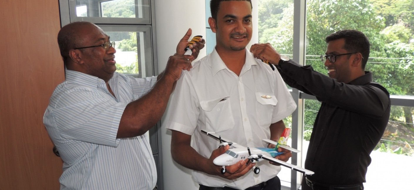 Captain Granger Narara, Head of Flight Operations (left), and Manoj Papa, Air Seychelles’ Chief Executive Officer (right), congratulate Captain Romain on his promotion