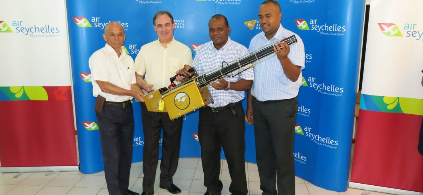 Paul Labaleine, Director General of DRDM, Roy Kinnear, Chief Executive Officer of Air Seychelles, Didier Dogley, Minister of Environment, Energy and Climate Change, and Wallace Cosgrow, Minister of Fisheries and Agriculture, hold a state-of-the-art insect fogger transported by Air Seychelles from South Africa.
