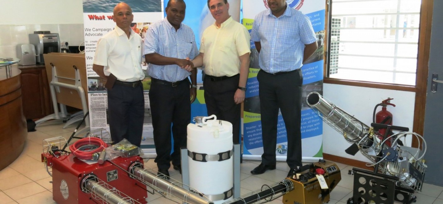 Paul Labaleine, Director General of DRDM, Didier Dogley, Minister of Environment, Energy and Climate Changem Roy Kinnear, Chief Executive Officer of Air Seychelles and Wallace Cosgrow, Minister of Fisheries and Agriculture, stand next to specialised fogging equipment transported by Air Seychelles.