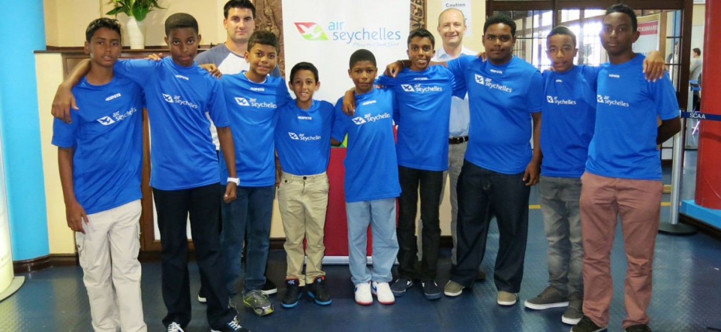 Young footballers from Foot Access pose next to coach Emmanuel Couzigou (left) and Rupert Hugh-Jones, Air Seychelles’ Head of Corporate Communications, after returning from France