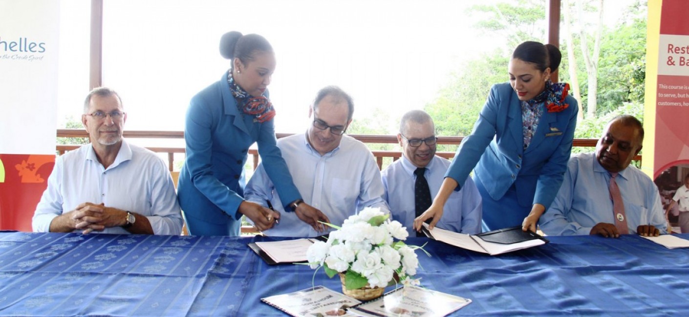 (Centre) Roy Kinnear, Chief Executive Officer of Air Seychelles, and Flavien Joubert, Principal of the Seychelles Tourism Academy, sign an MoU covering areas of cooperation for employment and on-the-job training for students at the academy