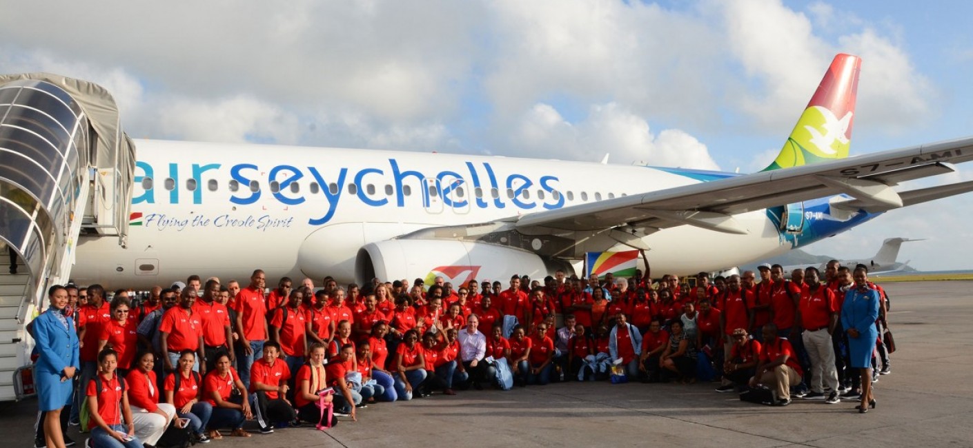 Roy Kinnear (centre), Chief Executive Officer of Air Seychelles, shares the excitement of the Seychelles delegation departing on the special morning flight to Réunion for the Indian Ocean Island Games